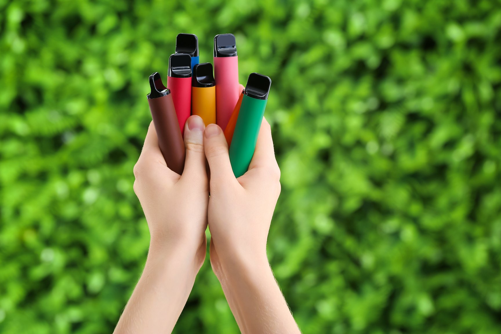 Female Hands with Disposable Electronic Cigarettes Outdoors, Closeup